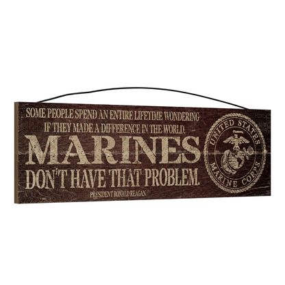 Angled view of the Marines Make a Difference 5 x 16 wood sign, showing the board thickness and wire hanger