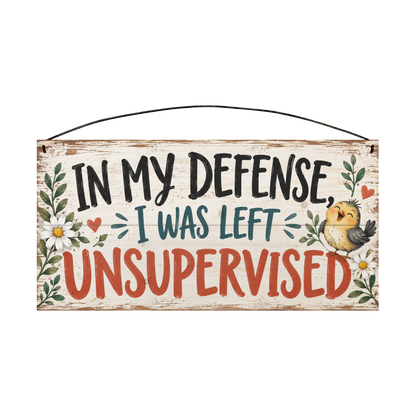 In My Defense I Was Left Unsupervised wood sign, 7 x 14 in, black teal and red-orange brush lettering with a laughing yellow chick and daisies on whitewashed pine