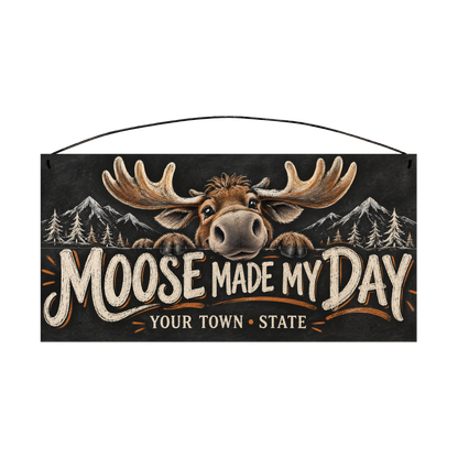 Personalized Moose Made My Day wood sign, 7 x 14 in — Grinning cartoon moose peeking over the lettering, with your town and state