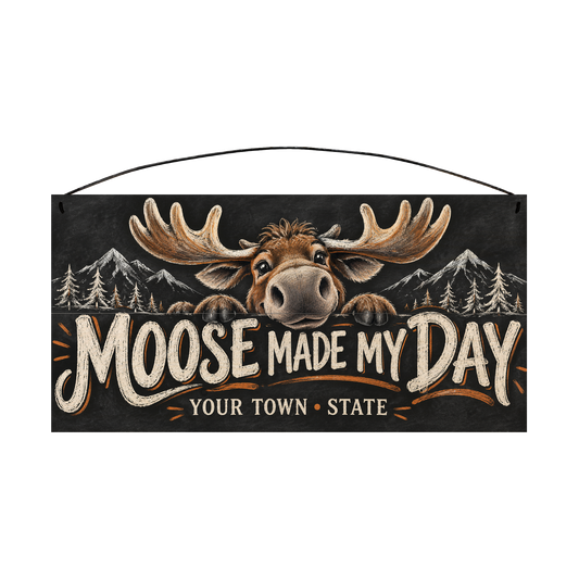 Personalized Moose Made My Day wood sign, 7 x 14 in — Grinning cartoon moose peeking over the lettering, with your town and state