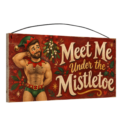 Angled view of the Meet Me Under the Mistletoe Elf Wood Sign 7 x 14 pine wood sign showing the board edge and hanging wire