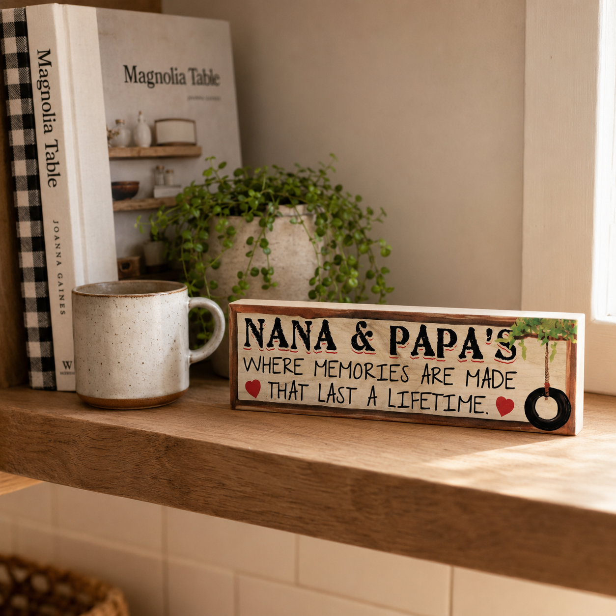 Twelve-inch Nana and Papa maple sign standing on a sunny kitchen shelf beside a mug, cookbook, and plant.